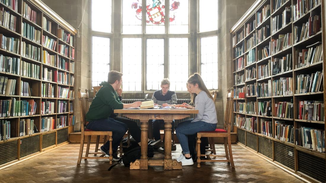 Students reading and working together in one of the libraries traditional reading rooms, on the Main Arts campus