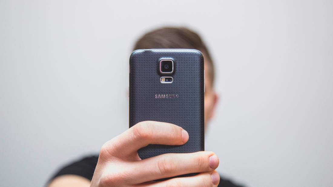 a mobile phone hides the face os someone taking a 'selfie'