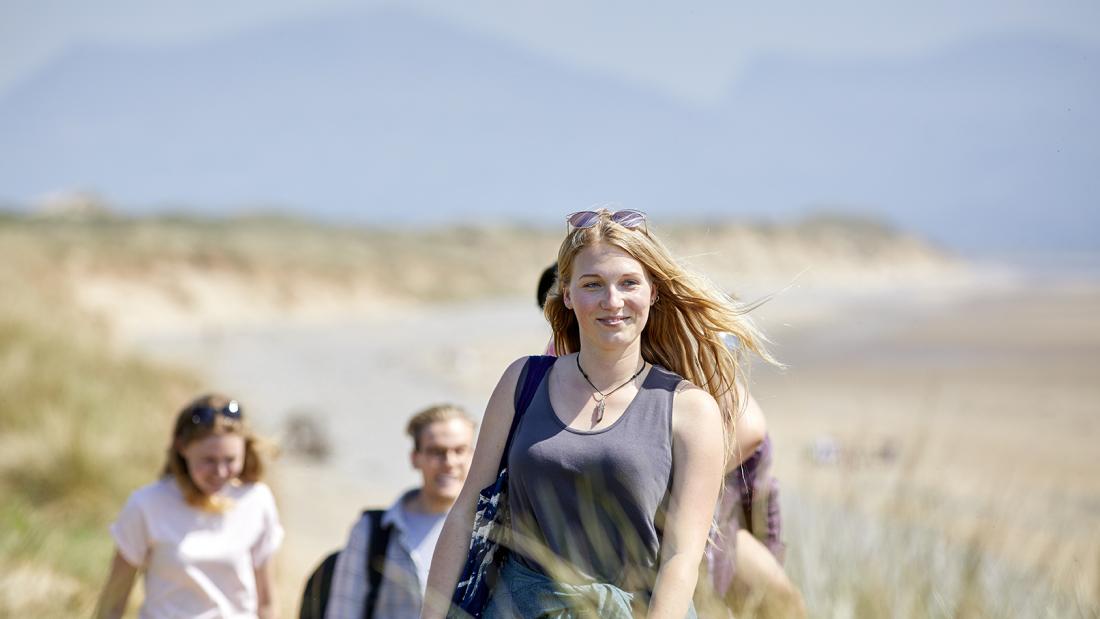 Image of students at the beach smiling