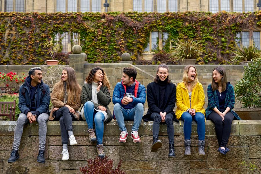 Students sitting on the wall in the inner quad of the Main Arts Building