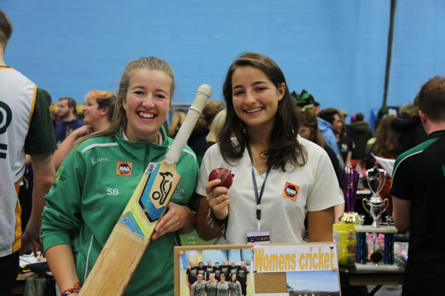 Two students from the Women's Cricket club at the Serendipity Fair during Welcome Week