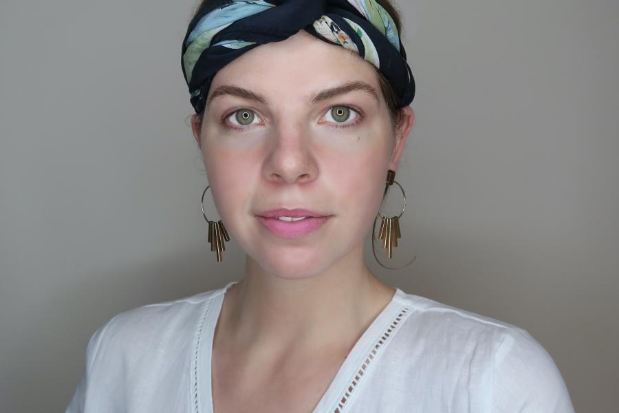 Young woman with headscarf looks into camera