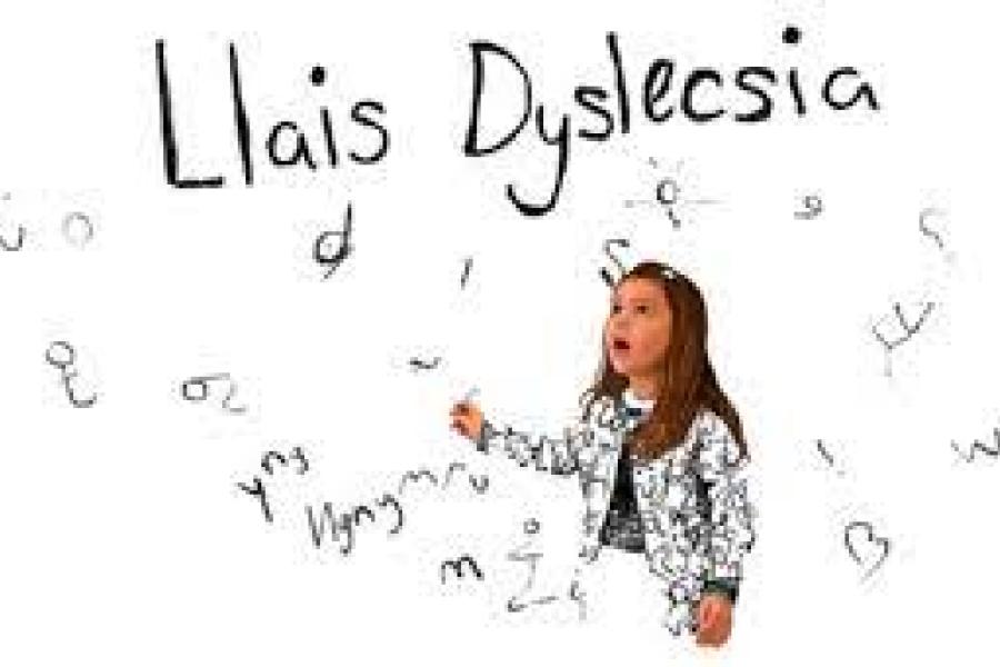 A young child standing surrounded by letters with the words 'Llais Dyslecsia' written in larger font 