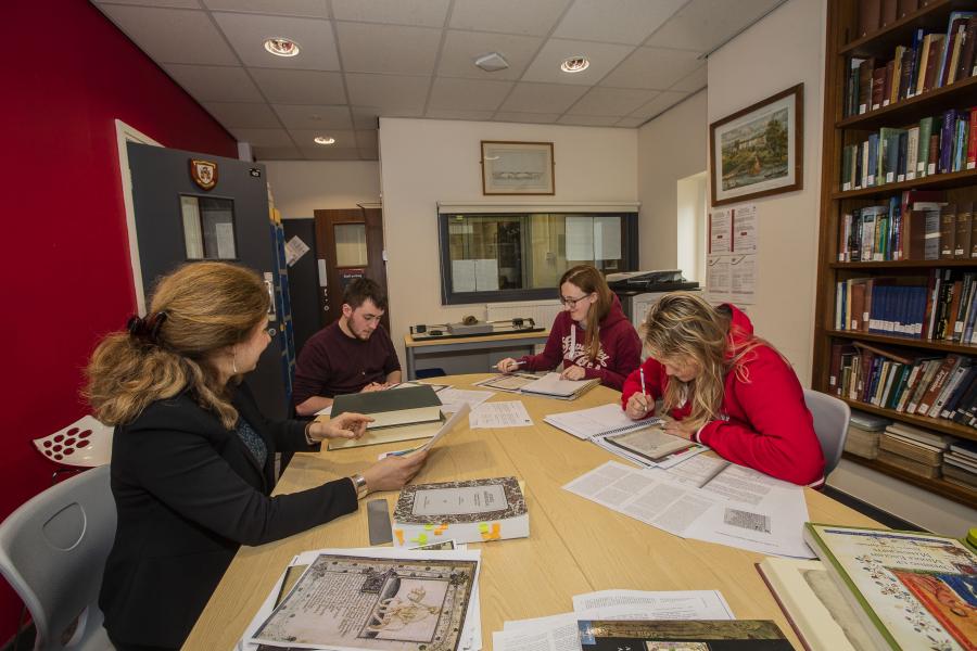 A photo of people researching collections in the archives reading room
