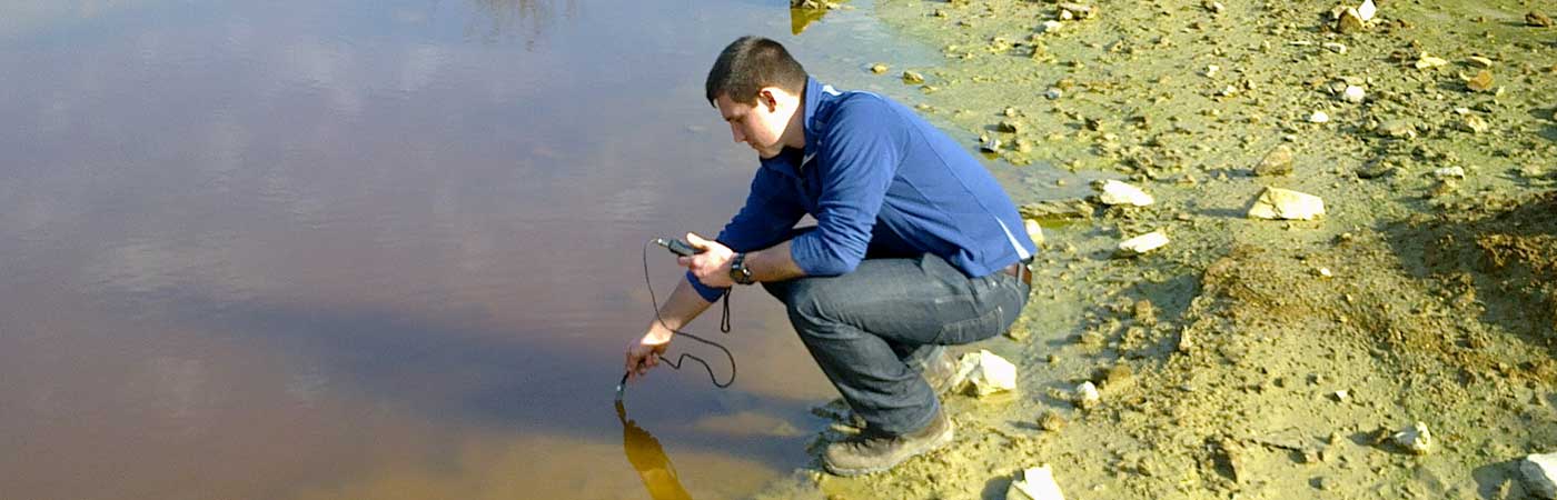 'Student measuring the water pH in abandoned mile tailings at Wheal Maid in Cornwall.