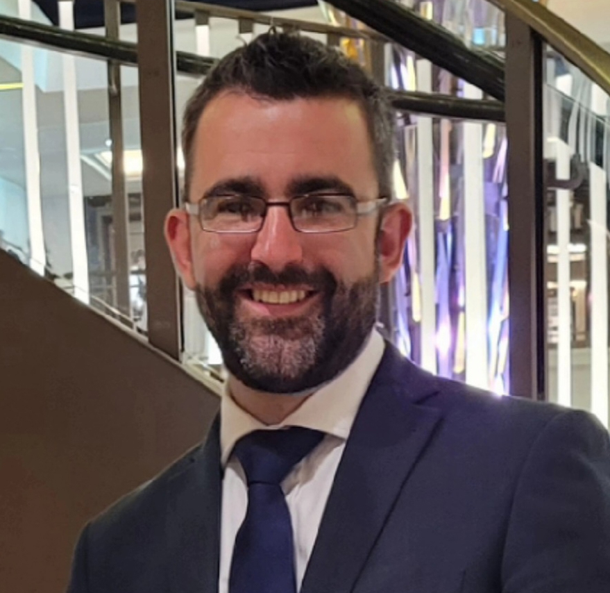 Edward Roberts, wearing glasses and a dark suit an tie