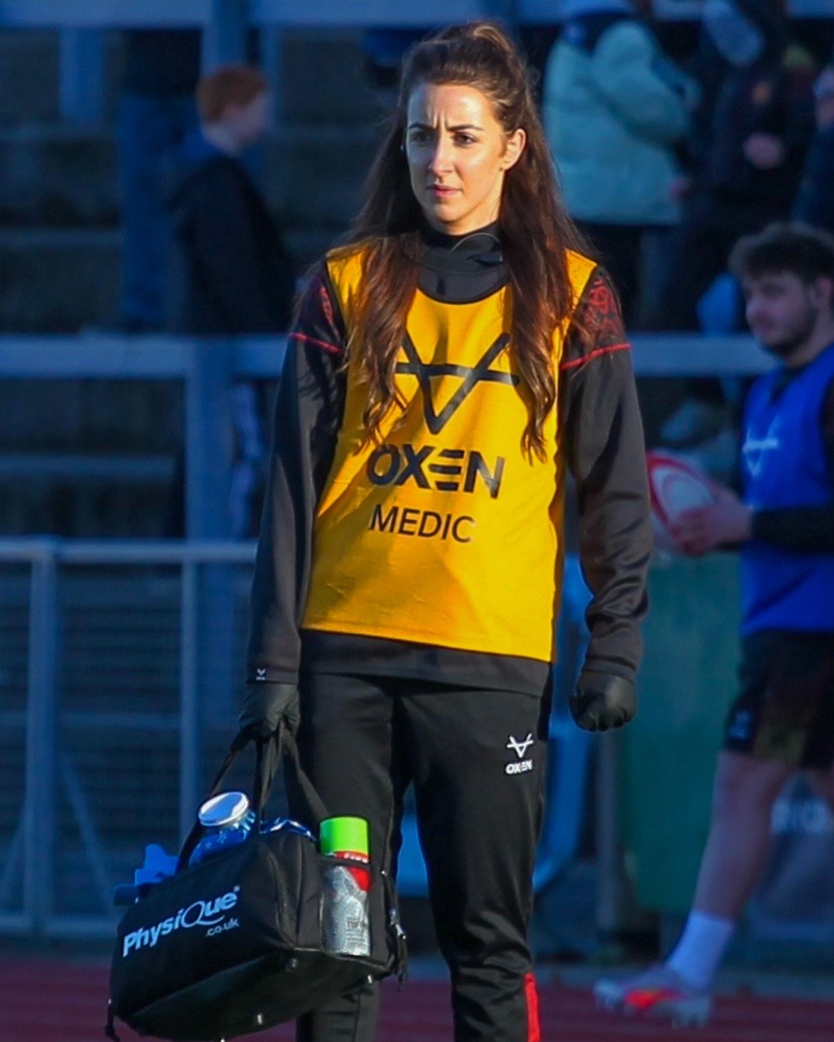 Dr Seren Evans on the rugby pitch with medic back wearing orange medic bib
