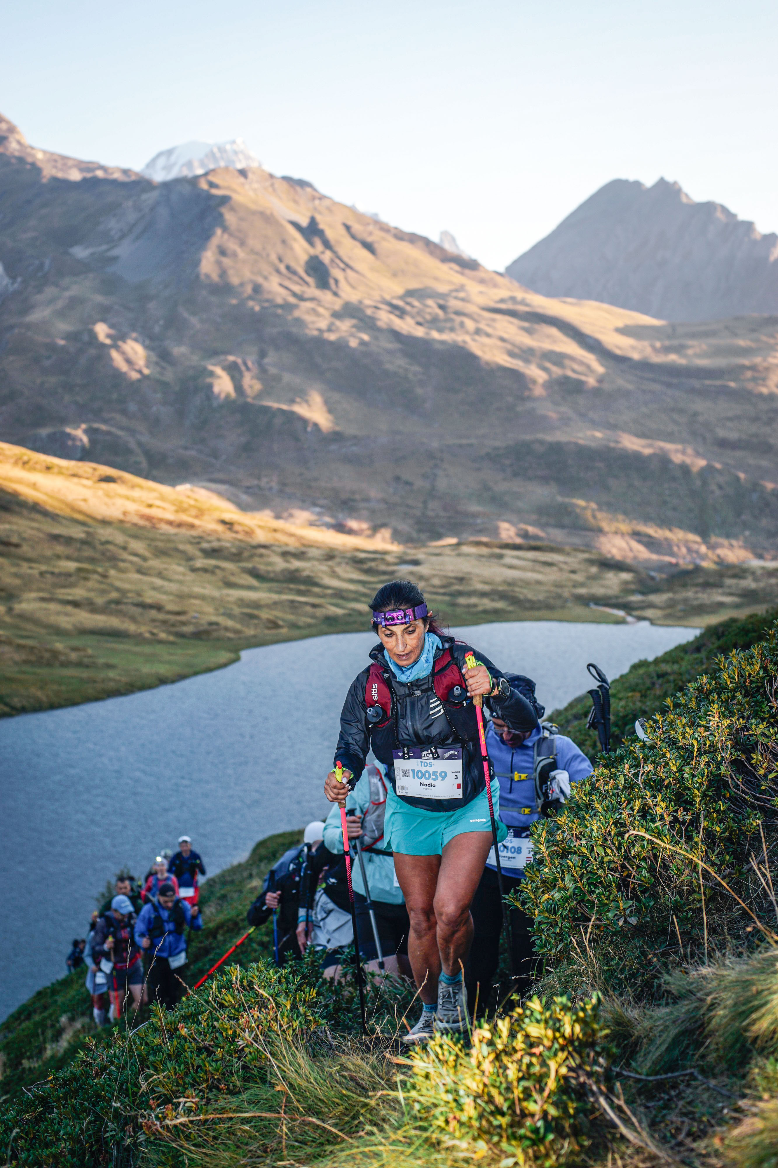 Nadia yn rhedeg ultra marathon gyda mynyddoedd yn y cefndir