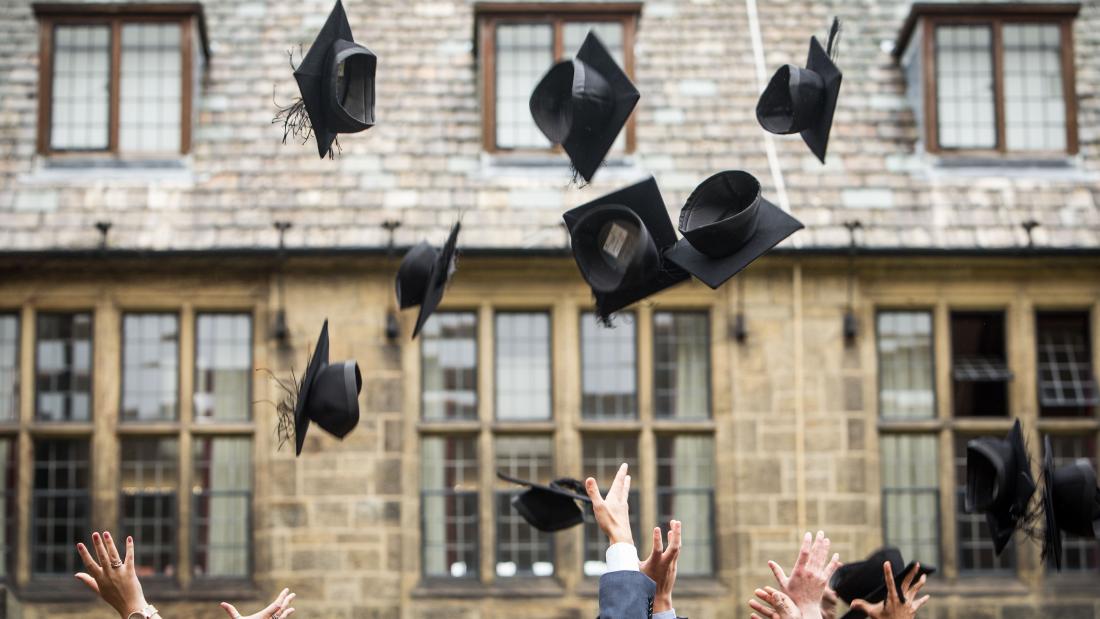 Students celebrating by throwing their caps in the air after their graduation ceremony