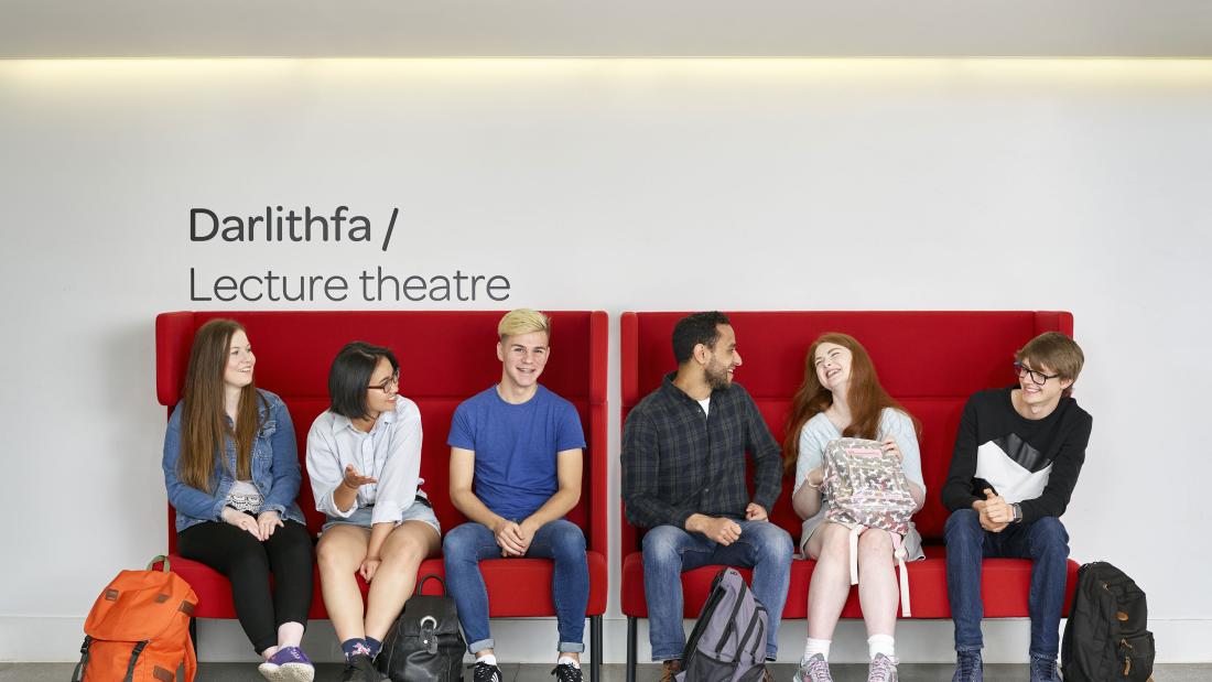 Students sitting outside the Lecture Theatre in Pontio