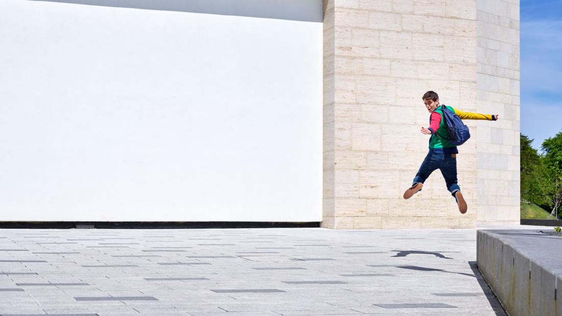A student jumping outside the Pontio building