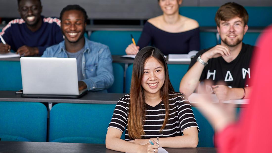 A group of students smiling during a lecture