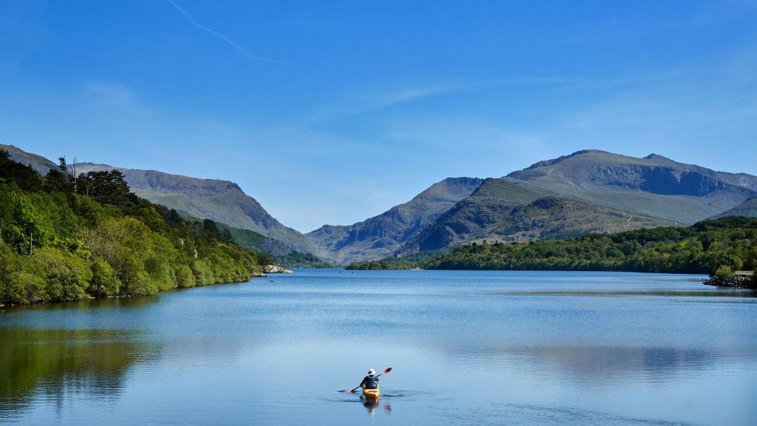 Myfyriwr mewn caiac ar Lyn Padarn yn Llanberis