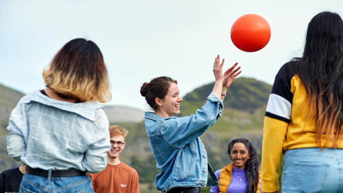 Students playing with a ball on a nearby beach