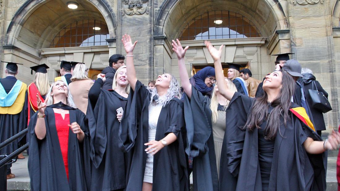 A group of students throwing their caps in their air after their graduation ceremony
