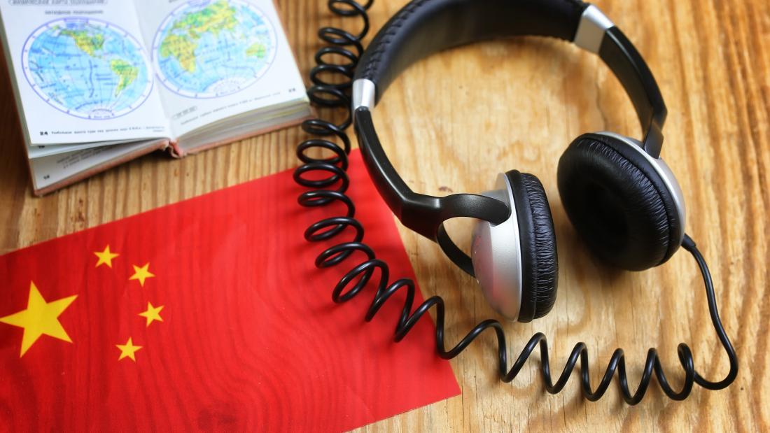 Table with headphones, book and Chinese flag