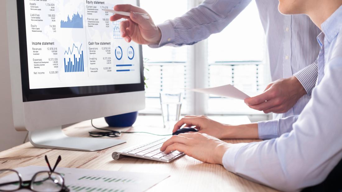 Professionals looking at a financial report on a computer