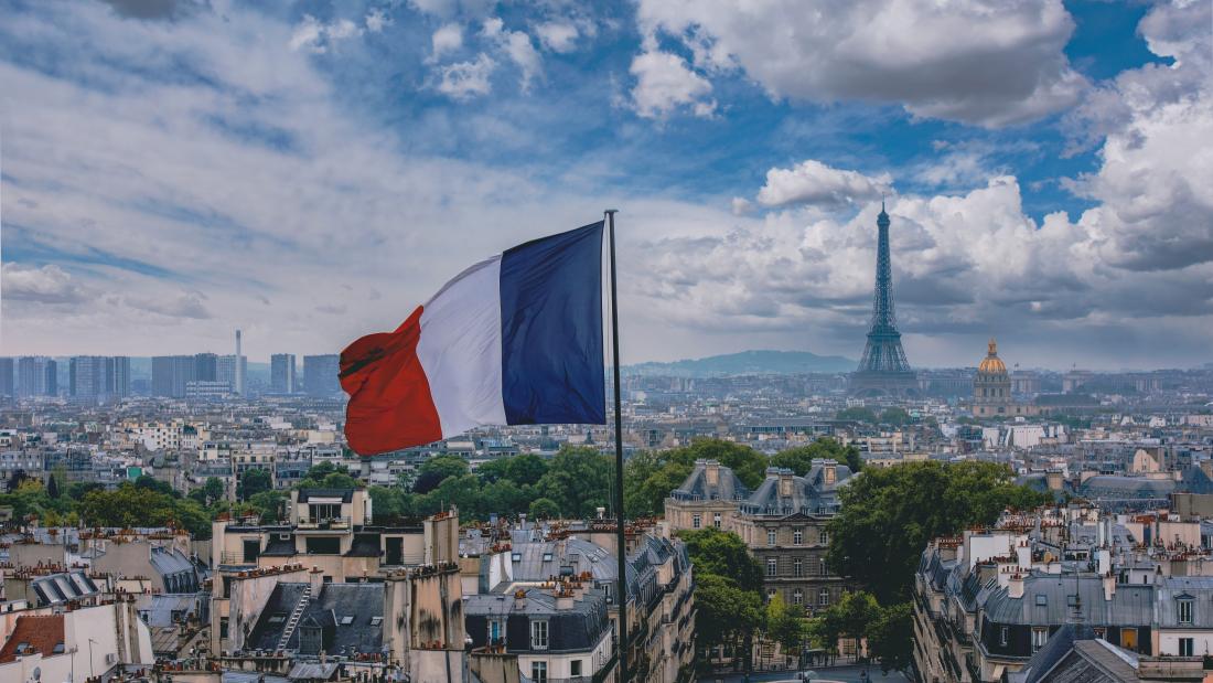 French flag flying in Paris with Eiffel Tower in the background