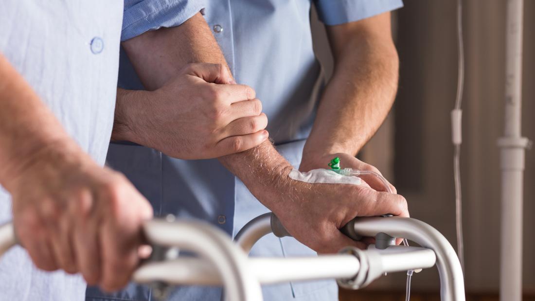 Health care nurse providing support and care to an elderly gentleman