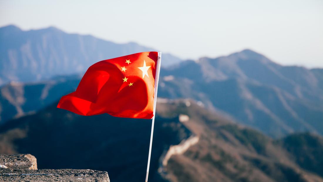 China flag flying over mountains in China