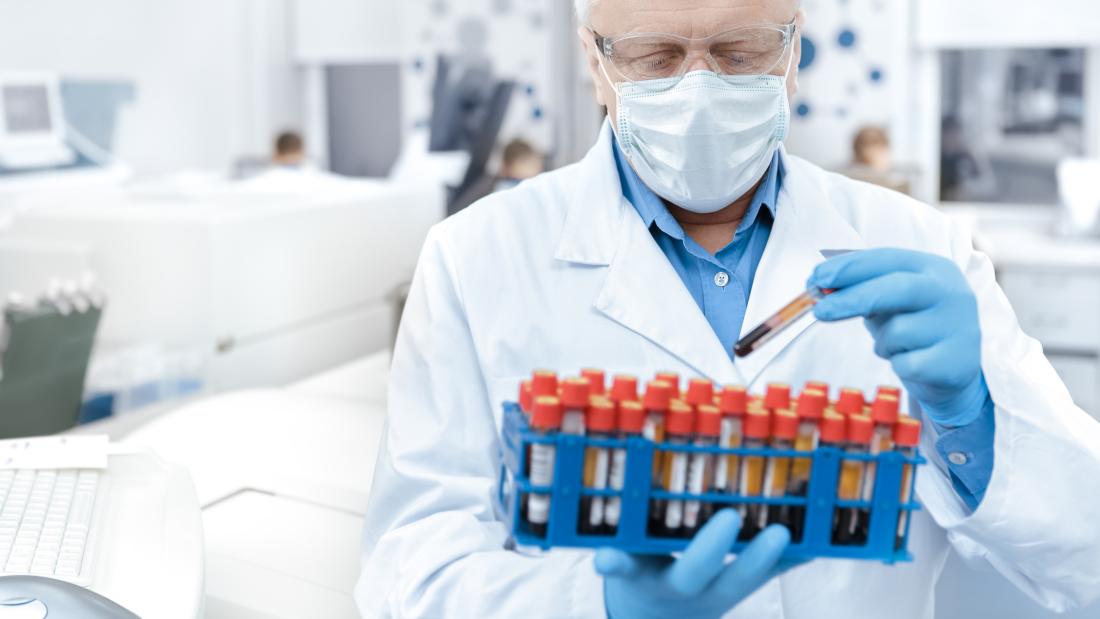 Scientist wearing protective mask working with blood samples in a laboratory