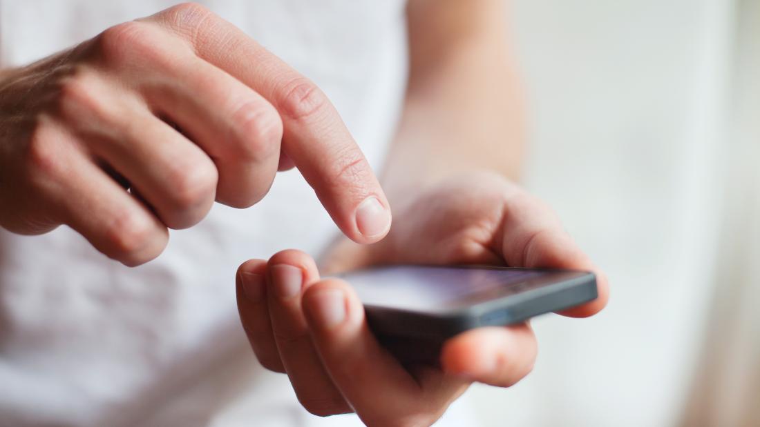 Hands typing on a smartphone