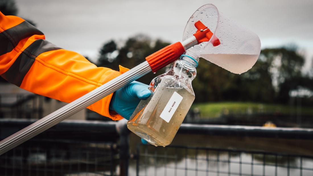 A member of staff tests waste water at a sewage plant