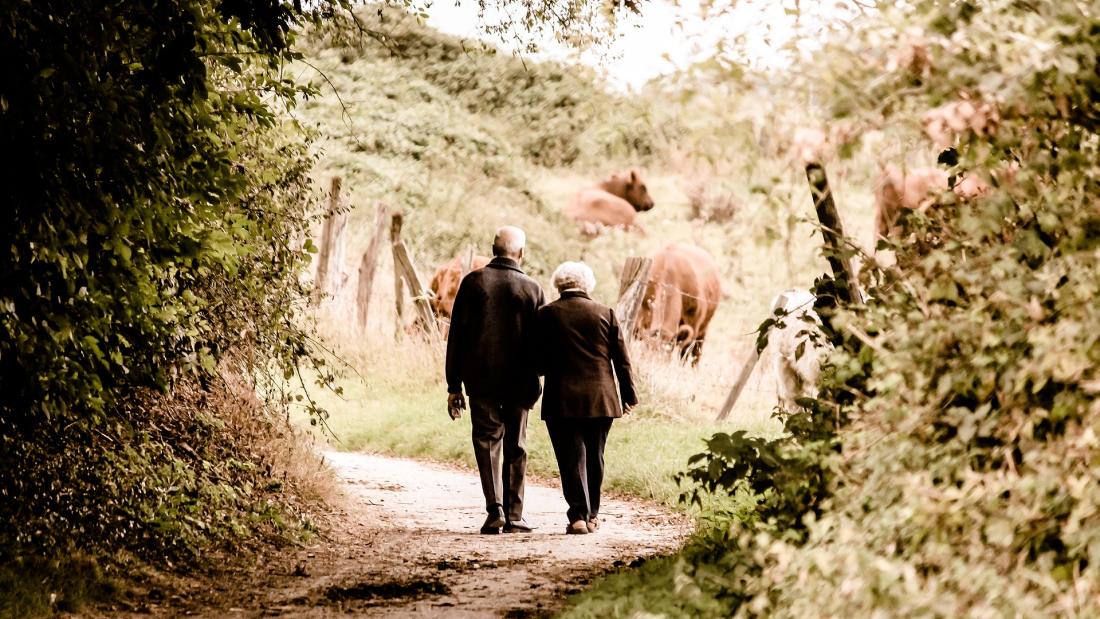 An older couple walking in countryside