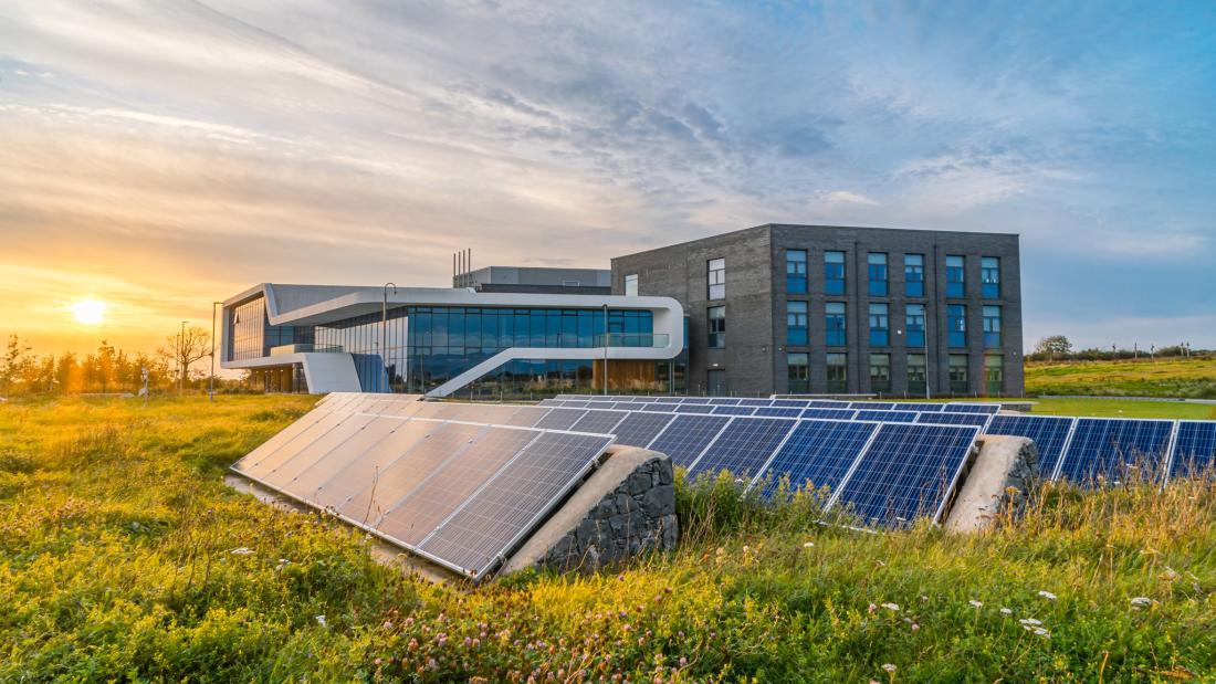 Modern building in field with solar panels in foreground