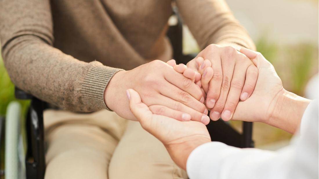 Carer holding patient's hands