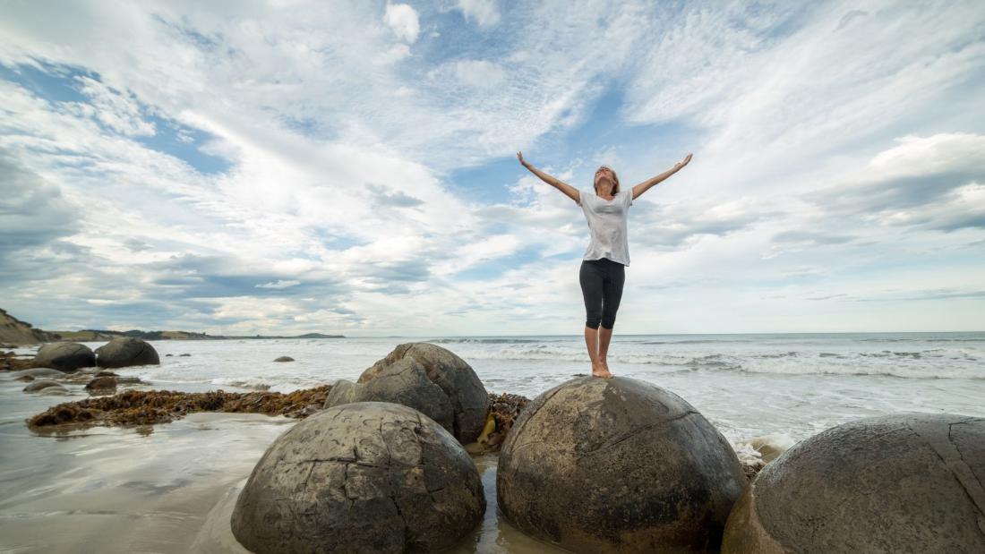 Woman standing on a rock at the beach