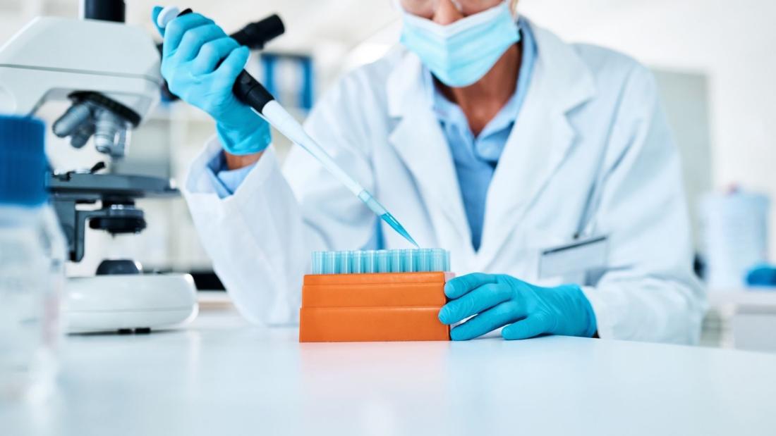 A woman in a white coat tesing in a lab