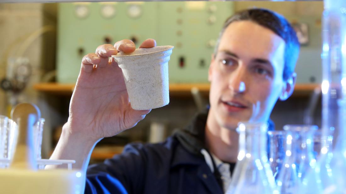 Person holds a moulded paper cup