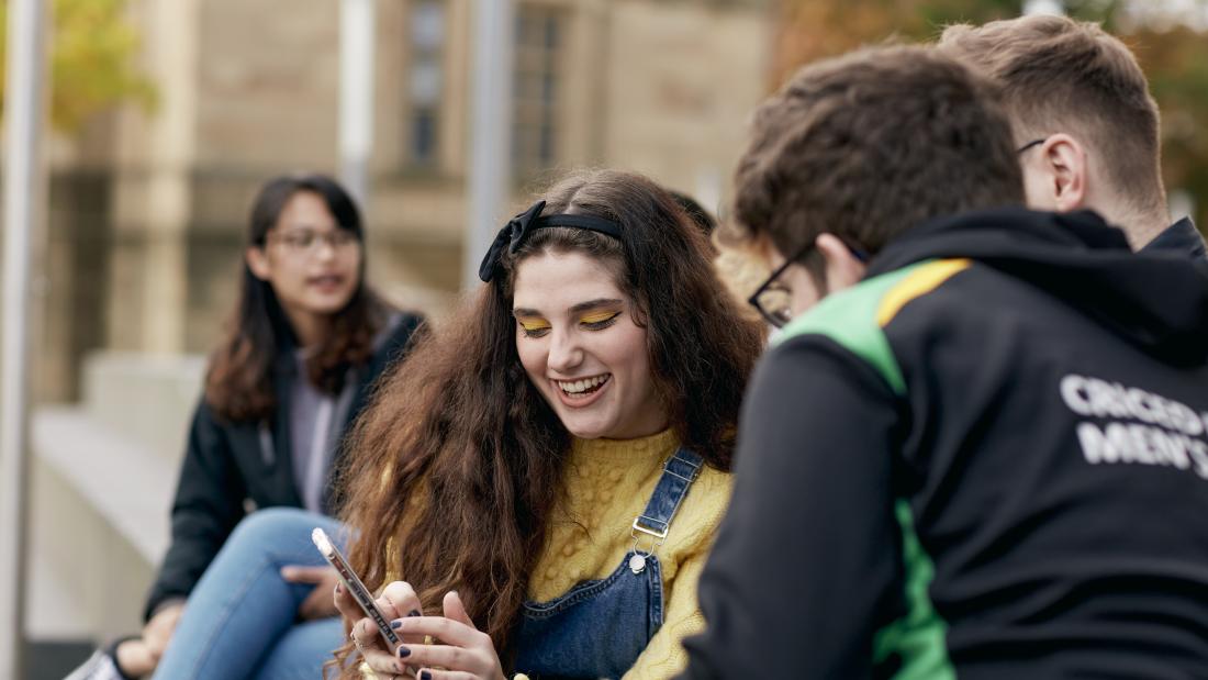 Students socialising and looking at phone