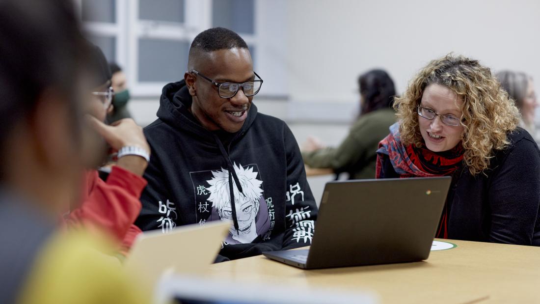 Students studying at table with laptop