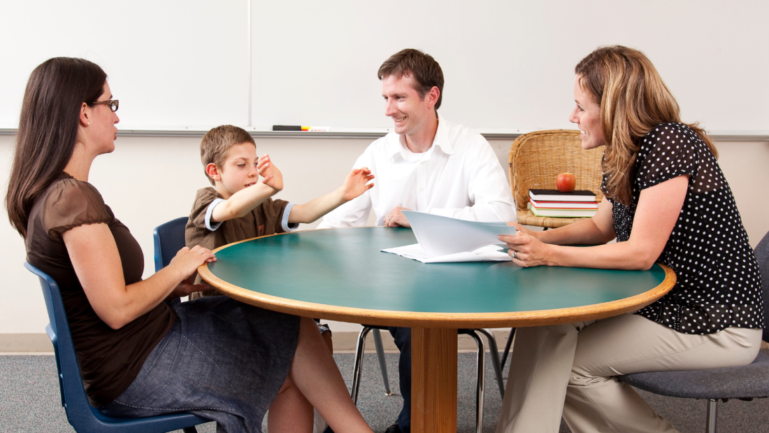 Parents, child and advisor sitting round a table