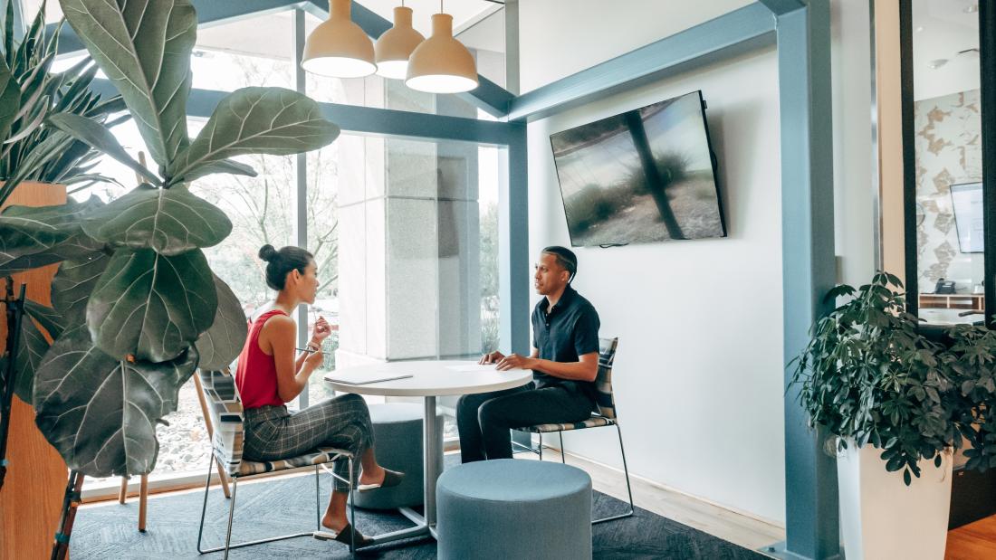 a picture of two people discussing sat down in an office enviroment