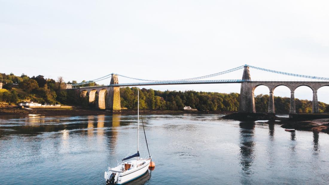 image of menai strait, bridge and a a boat sailing on the water