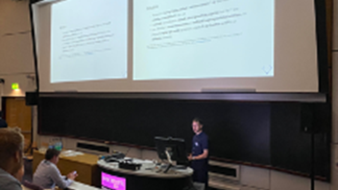 Dr Franck Vidal giving his oral presentation in a lecture room with students with a presentation showing