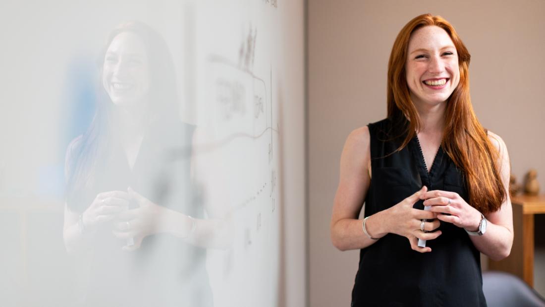 woman next to whiteboard