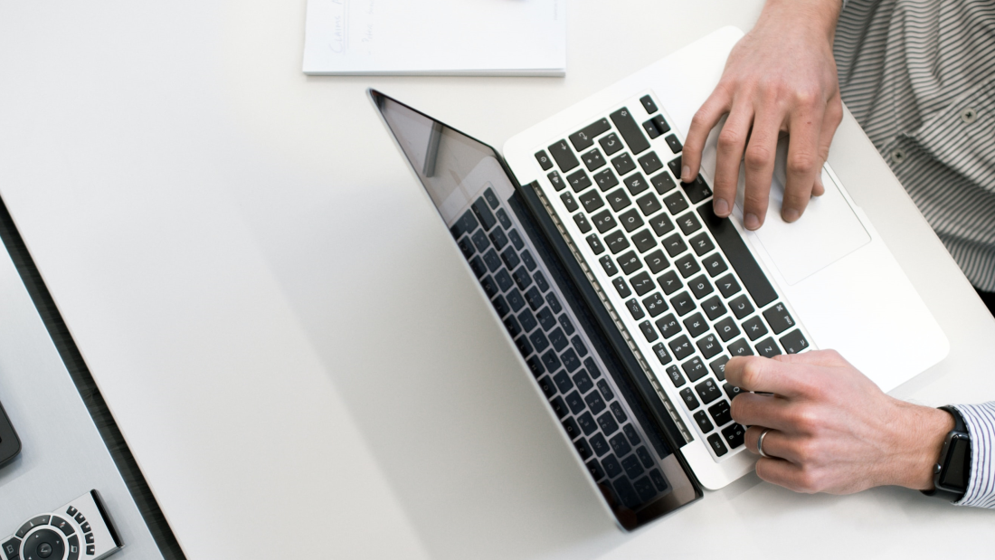 Person at a desk typing away at a laptop