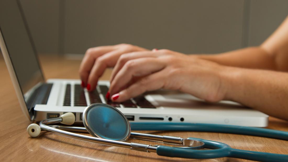 a stethoscope on the table next to a laptop 