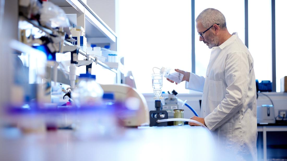 Male wearing a white coat in a Bangor University lab