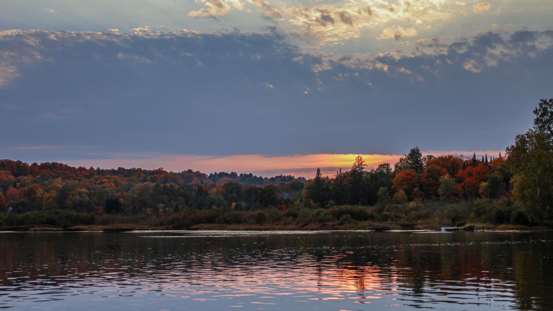 a landscape image of a lake and forrest during sunset 