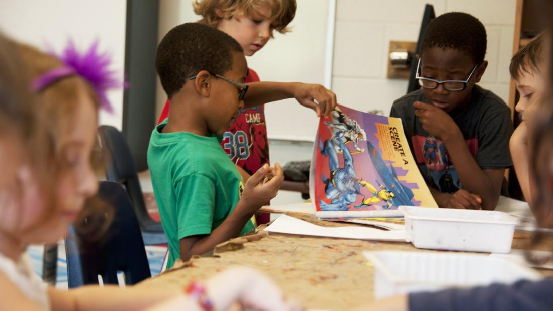 a classroom full of kids reading and drawing 