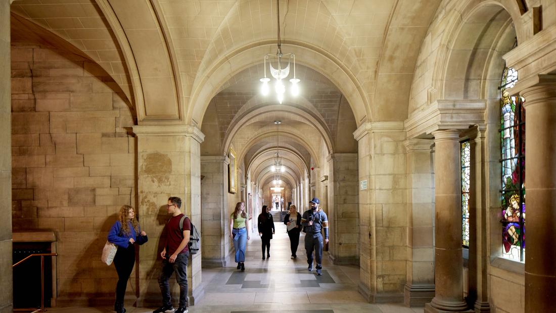 A group of students walking down the main corridor at the Main Arts building