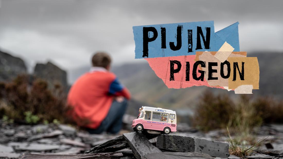 toy model of an ice cream van with young person sitting in the background looking over the mountains