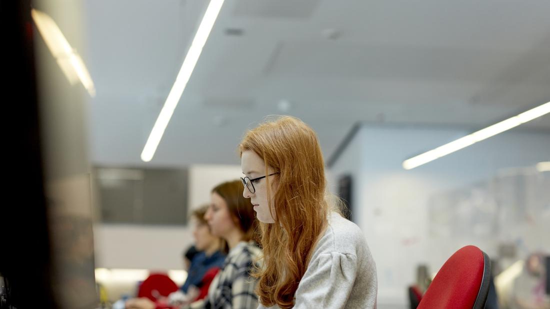 Students in a study room, working on computers