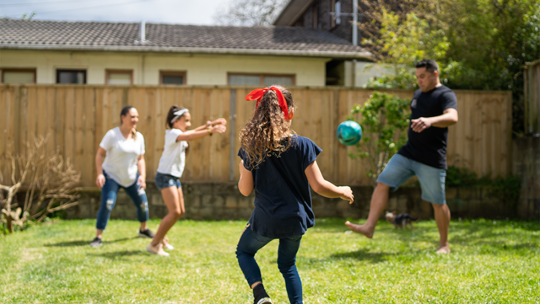 Family playing football in the garden