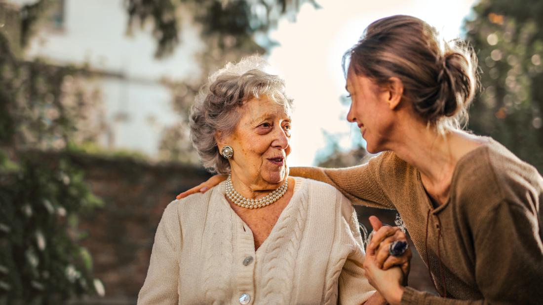 Image of two woman, older and younger, holding hands evoking emotional and support